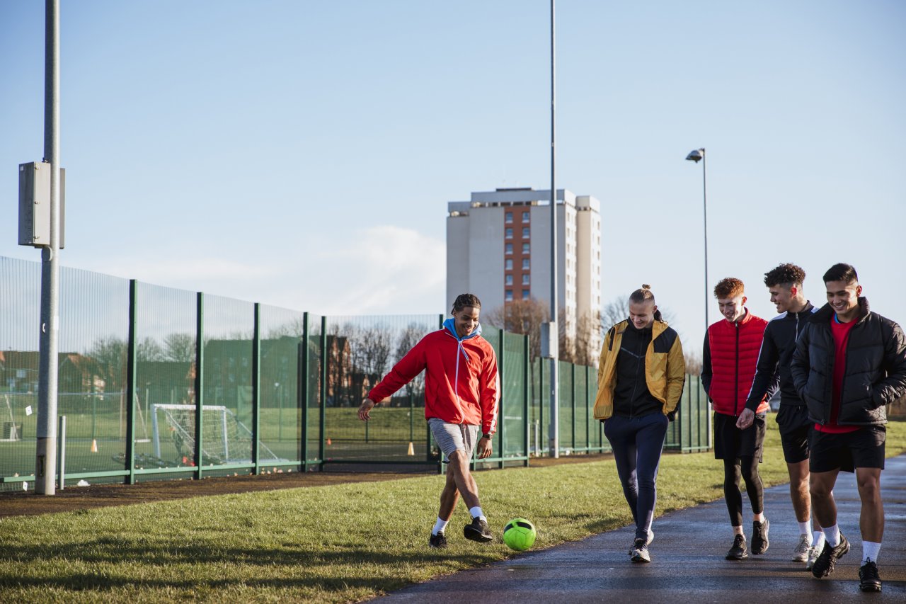 Teenagers playing football.